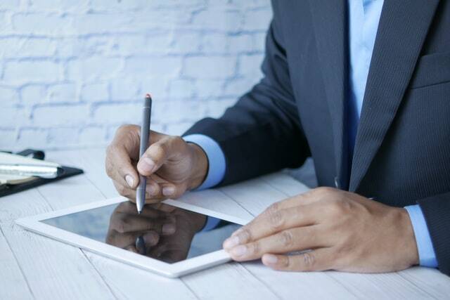 person in a suit working on an iPad